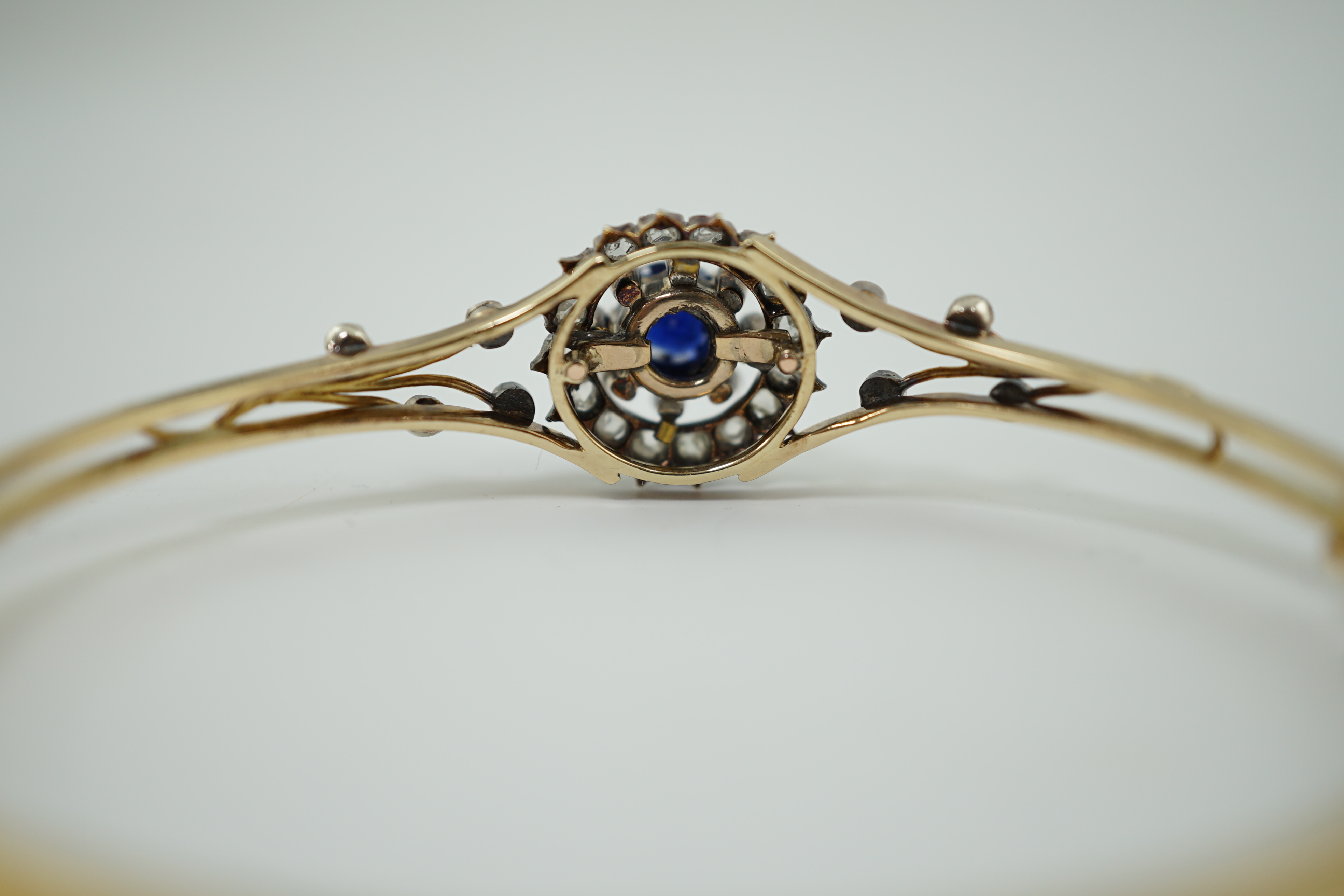 A Victorian gold, sapphire and diamond cluster set hinged bangle